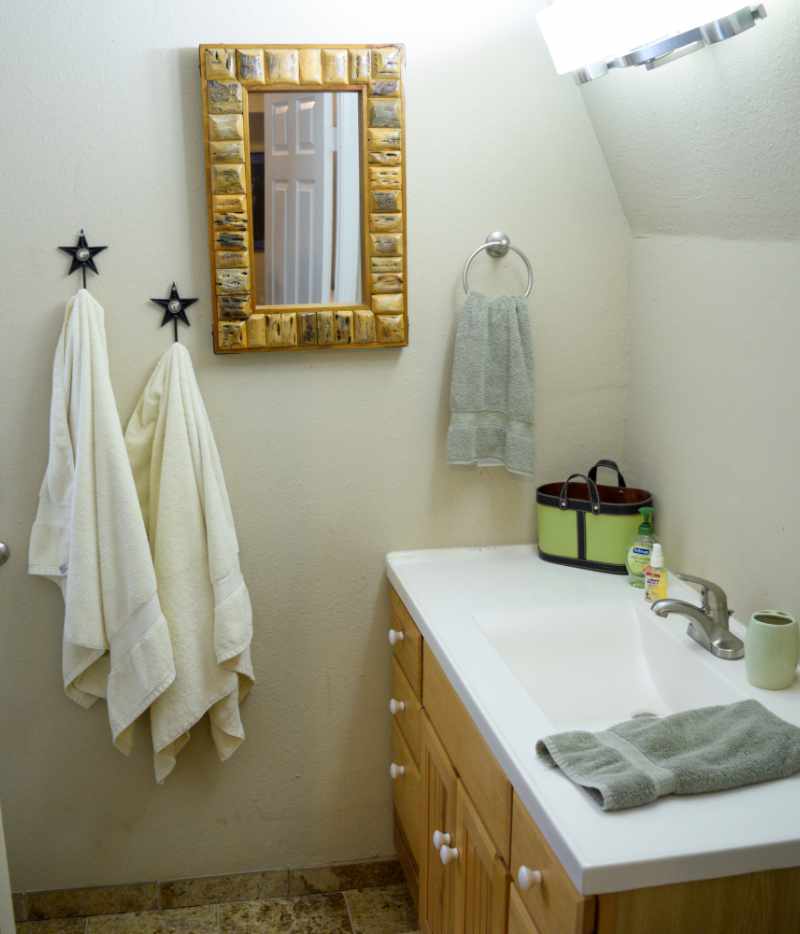 Bathroom with mirror, towels, and white vanity