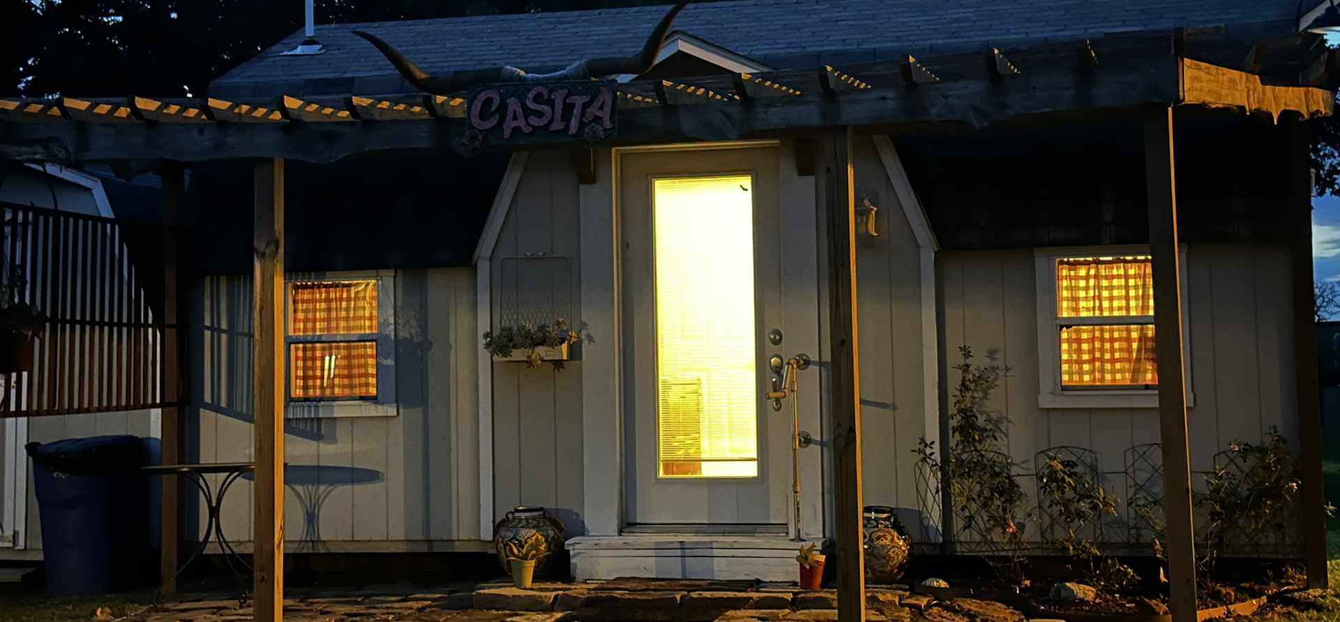 Cozy illuminated cabin at twilight with a 'Casita' sign