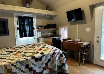 Cozy home interior with bed, kitchenette, and dining area.