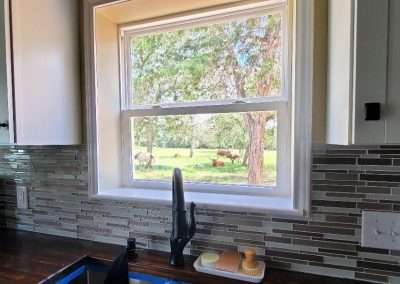 Kitchen window view of grazing horses outdoors