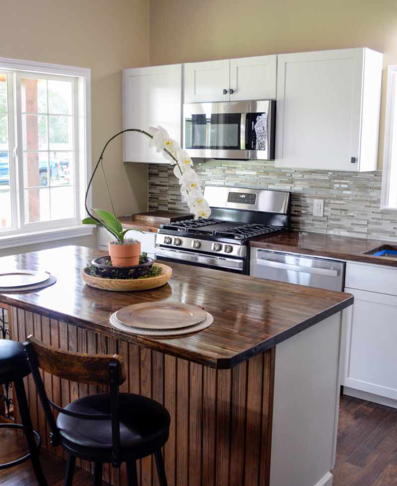 Modern kitchen with white cabinets and wooden countertop