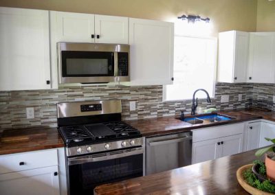 Modern kitchen with white cabinets and mosaic backsplash