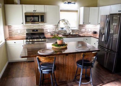 Modern kitchen with stainless steel appliances and barstools