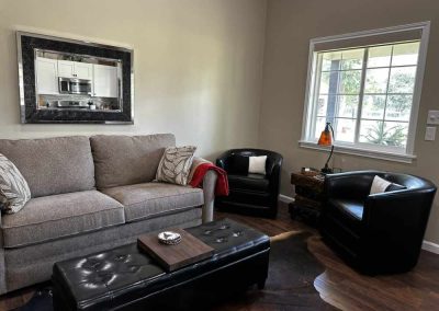 Cozy living room with sofa, chairs, and large window.