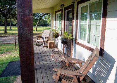 Cozy porch with wooden chairs and green lawn view