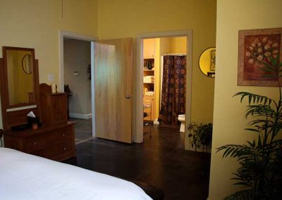 Spacious bedroom with open bathroom doorway and decor