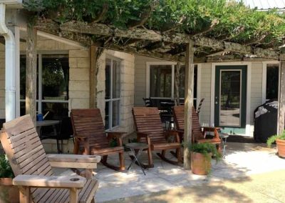 Cozy patio with wooden chairs and green pergola