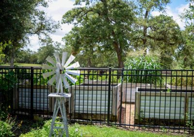 White windmill near fence overlooking gardens and trees
