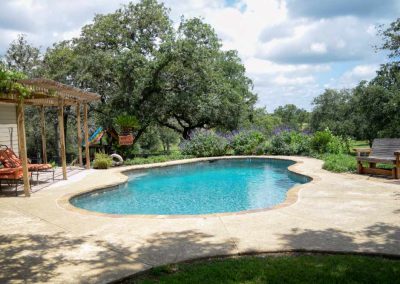 Beautiful backyard pool with pergola and lush greenery