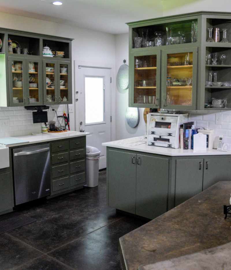 Modern kitchen with green cabinets and white countertops