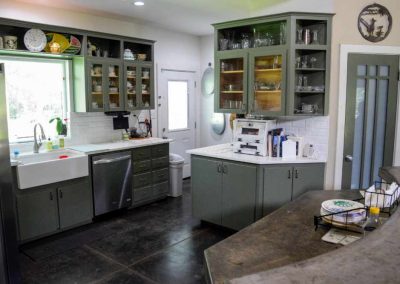 Spacious kitchen with green cabinets and modern appliances