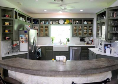 Spacious kitchen with green cabinets and modern appliances