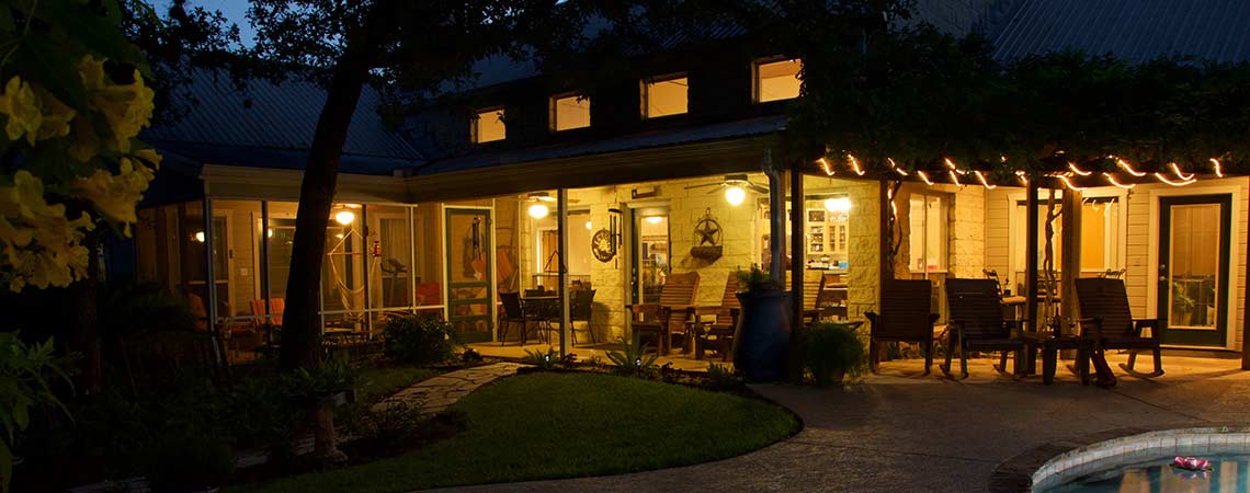 Illuminated backyard patio with pool at twilight