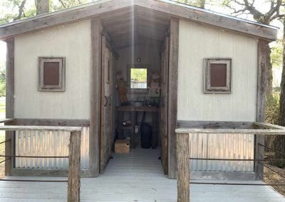 Rustic small cabin entrance with open door and deck