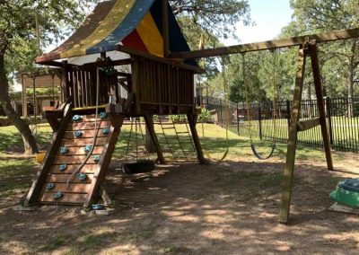 Colorful playground structure in sunny park with trees