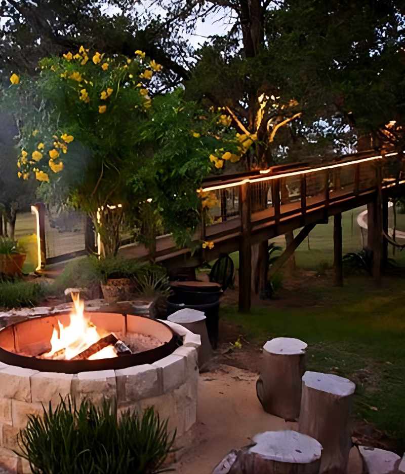 Cozy outdoor fire pit area with wooden bench at dusk