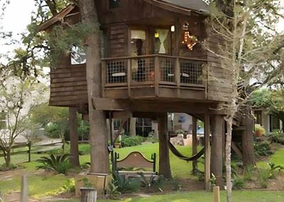 Rustic treehouse with balcony amid lush greenery