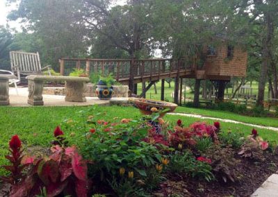 Colorful garden and wooden treehouse in lush green park