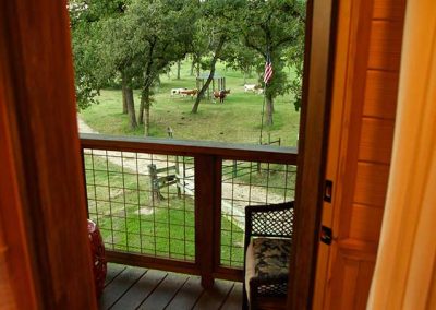 View from balcony overlooking peaceful green pasture with livestock