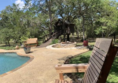Backyard with pool, fire pit, and wooden treehouse