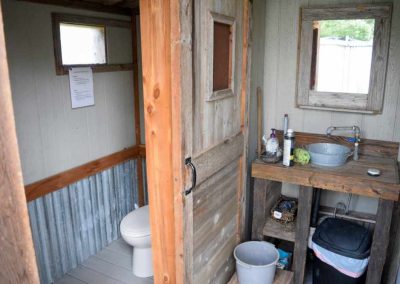 Rustic outdoor bathroom with wooden sink and toilet