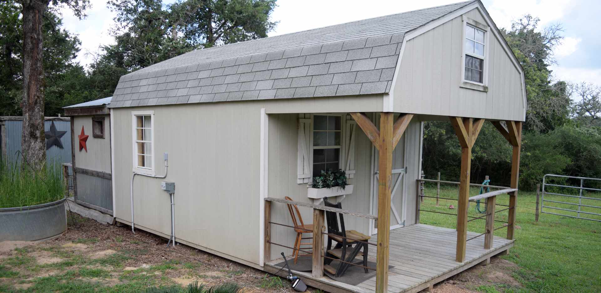 Rustic elevated shed with porch in rural setting