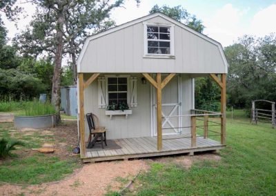 Small barn-style house with porch in rural setting