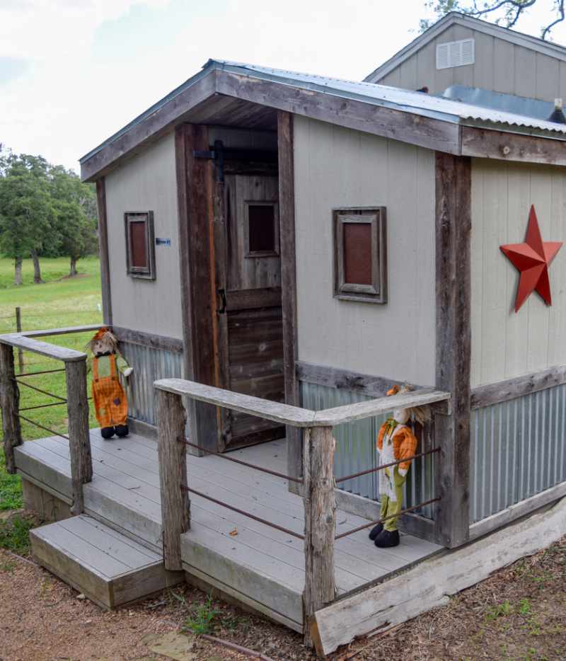 Rustic wooden shed with star decor and porch scarecrow